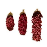 Three large dried red chile ristras on a white background