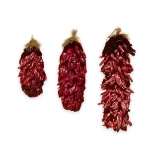 Three large dried red chile ristras on a white background